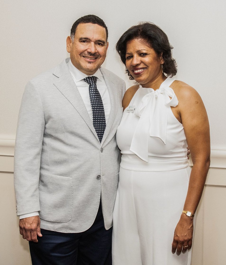 Luxurious empty gala dinner table setting with crystal glasses under warm chandelier lighting